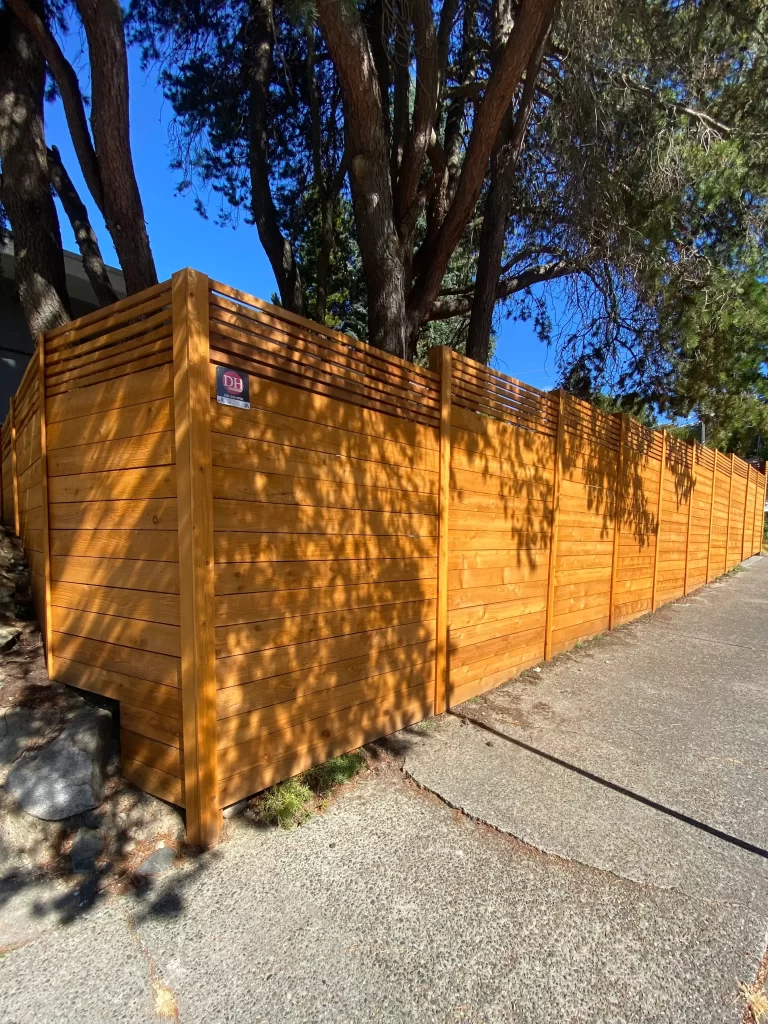 Horizontal cedar fence on sidewalk near Alki