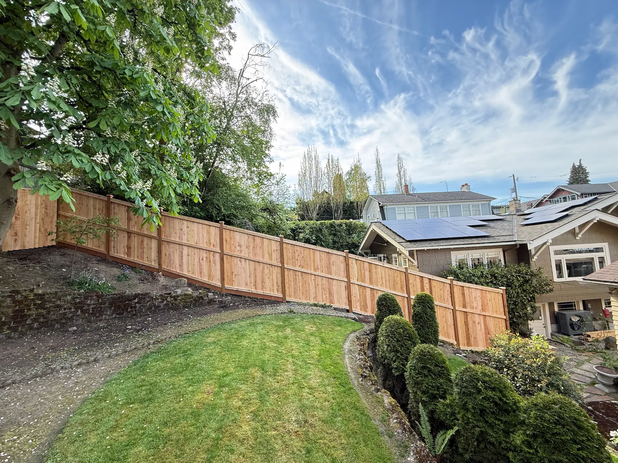 Custom cedar privacy fence installed on a sloped backyard property in Seattle, WA
