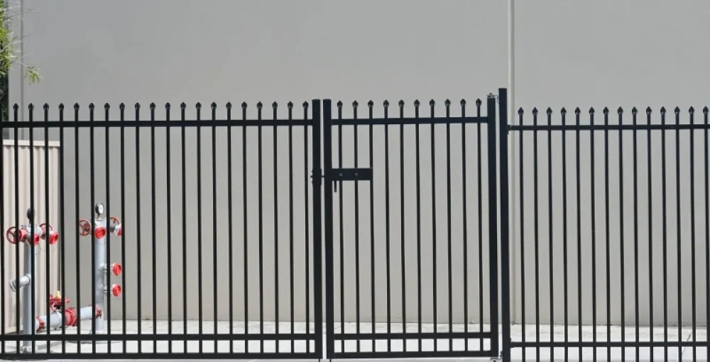 Aluminum fence with a secure gate installed along a commercial property